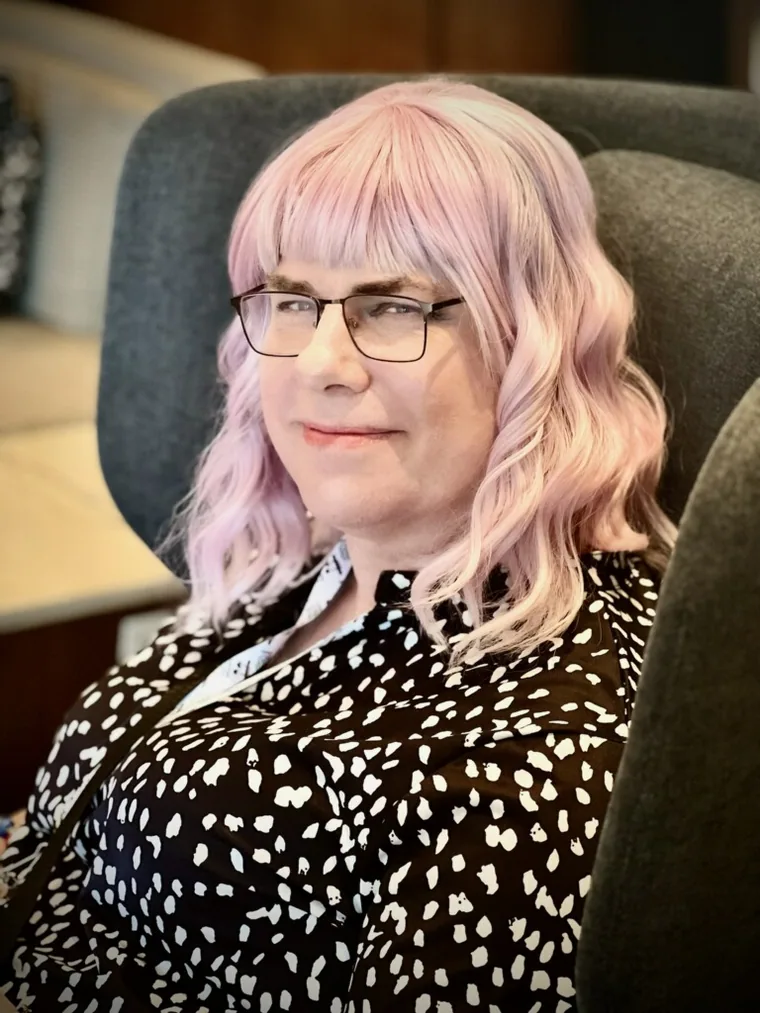 Erika X. Driscoll seated in a patterned black-and-white outfit